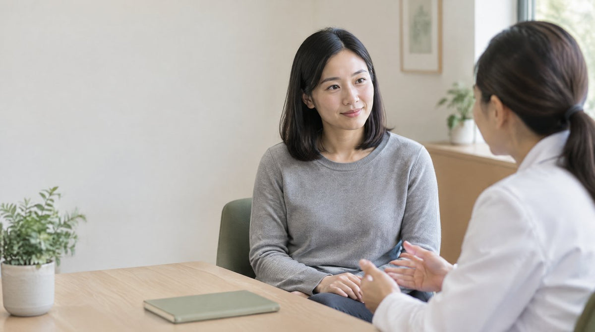 A woman listening calmly to a female doctor in a bright consultation room
