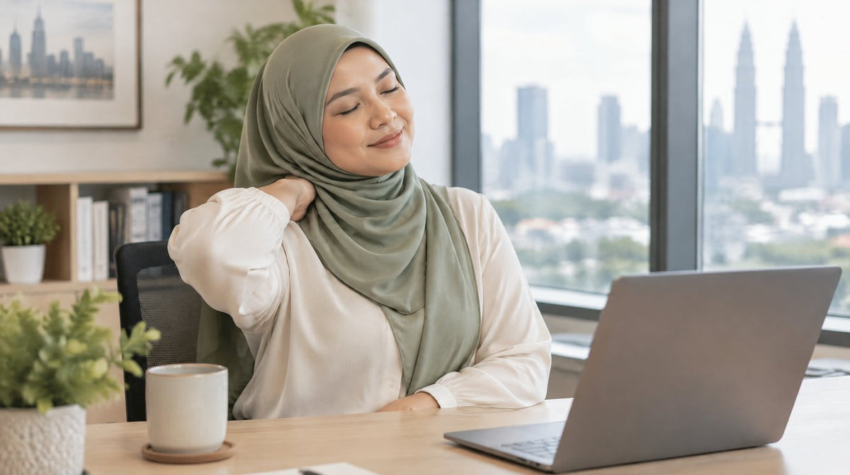A woman in a hijab stretching her neck and shoulder at her office desk