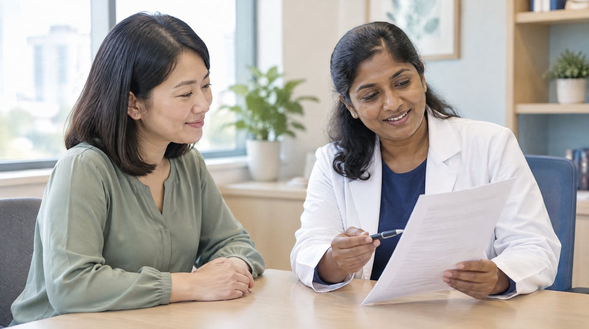 A doctor explaining a blood test report to a woman in a clinic