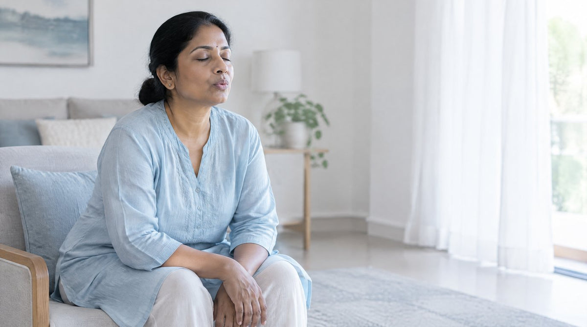 A woman sitting and leaning forward while practising slow pursed-lips breathing