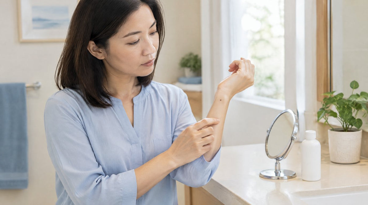 A woman checking a small mole on her wrist at home